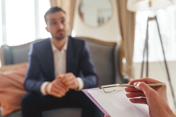 Closeup of a senior Caucasian womans hand holding a clipboard and a silver ball-point pen